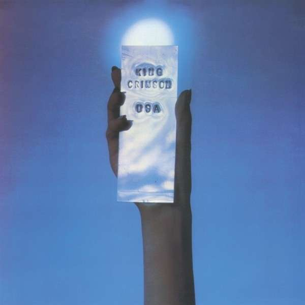 Album borító, egy kézzel tartva egy világító téglalapot. A 'King Crimson' és '09A' szöveg látható.