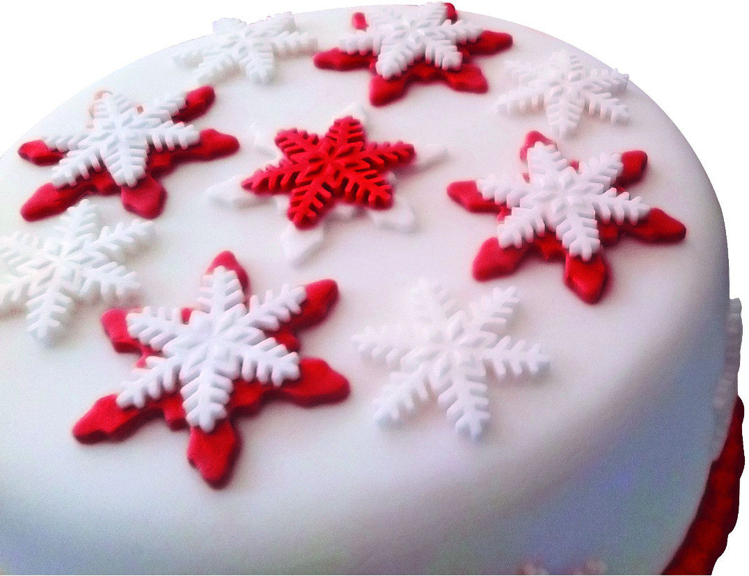 Kuchen, verziert mit weißen und roten Schneeflocken auf weißem Zuckerguss.