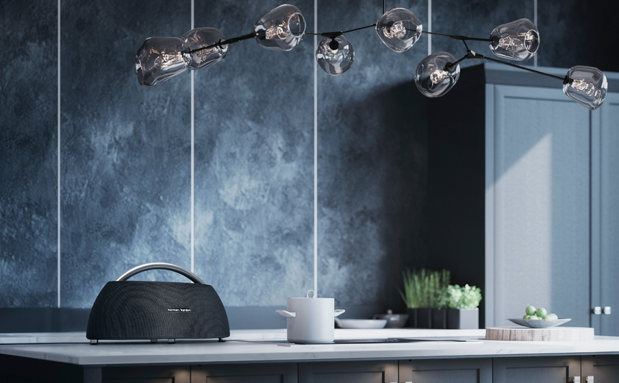 Moderne keukenscène met een luidspreker, pot en hanglamp.