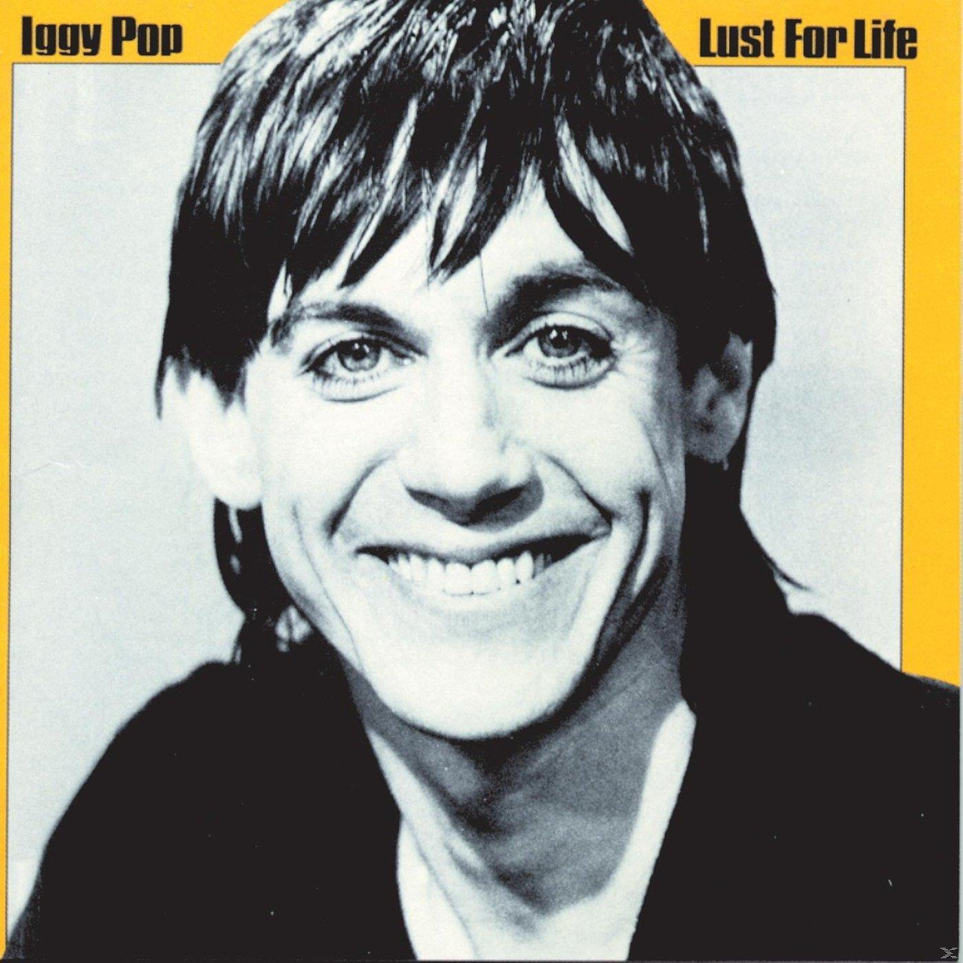 Iggy Pop album cover. Black and white photo of him smiling with a yellow background.