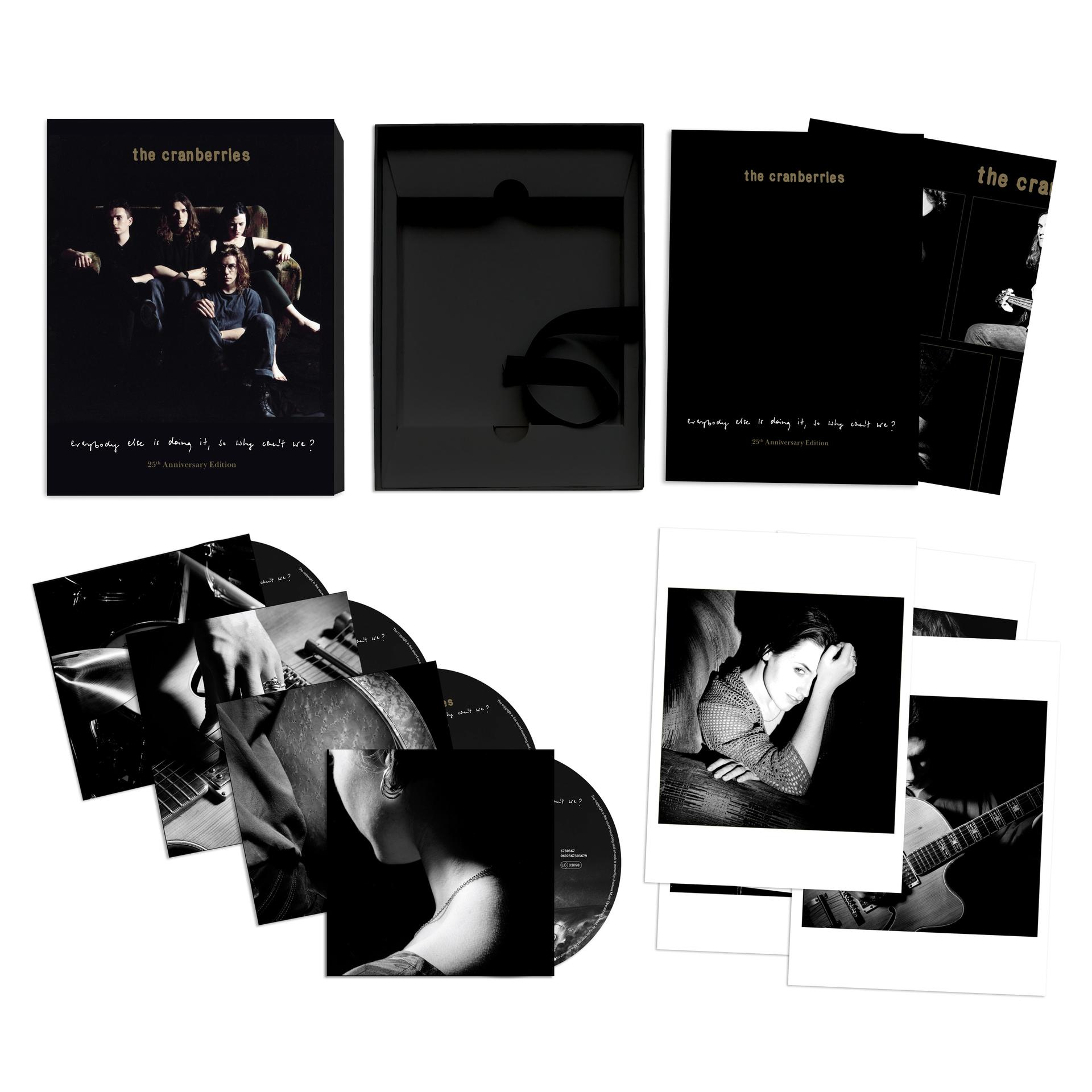 Een zwarte boxset van een muziekalbum, met een foto van een band en extra inlegvellen.