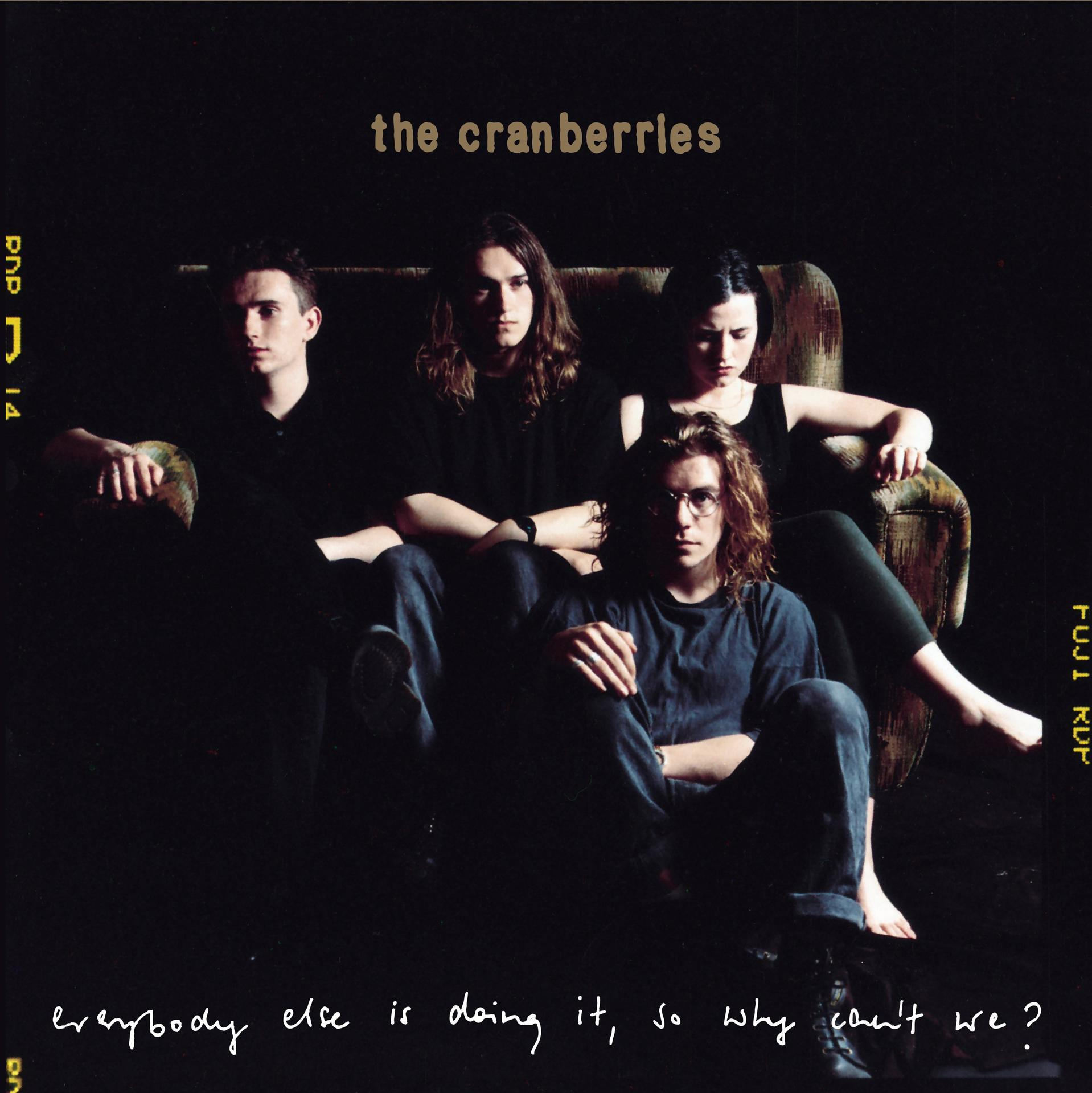 Pochette de l'album The Cranberries. Les membres du groupe sont assis sur un canapé, fond sombre. Texte : Everybody else is doing it.