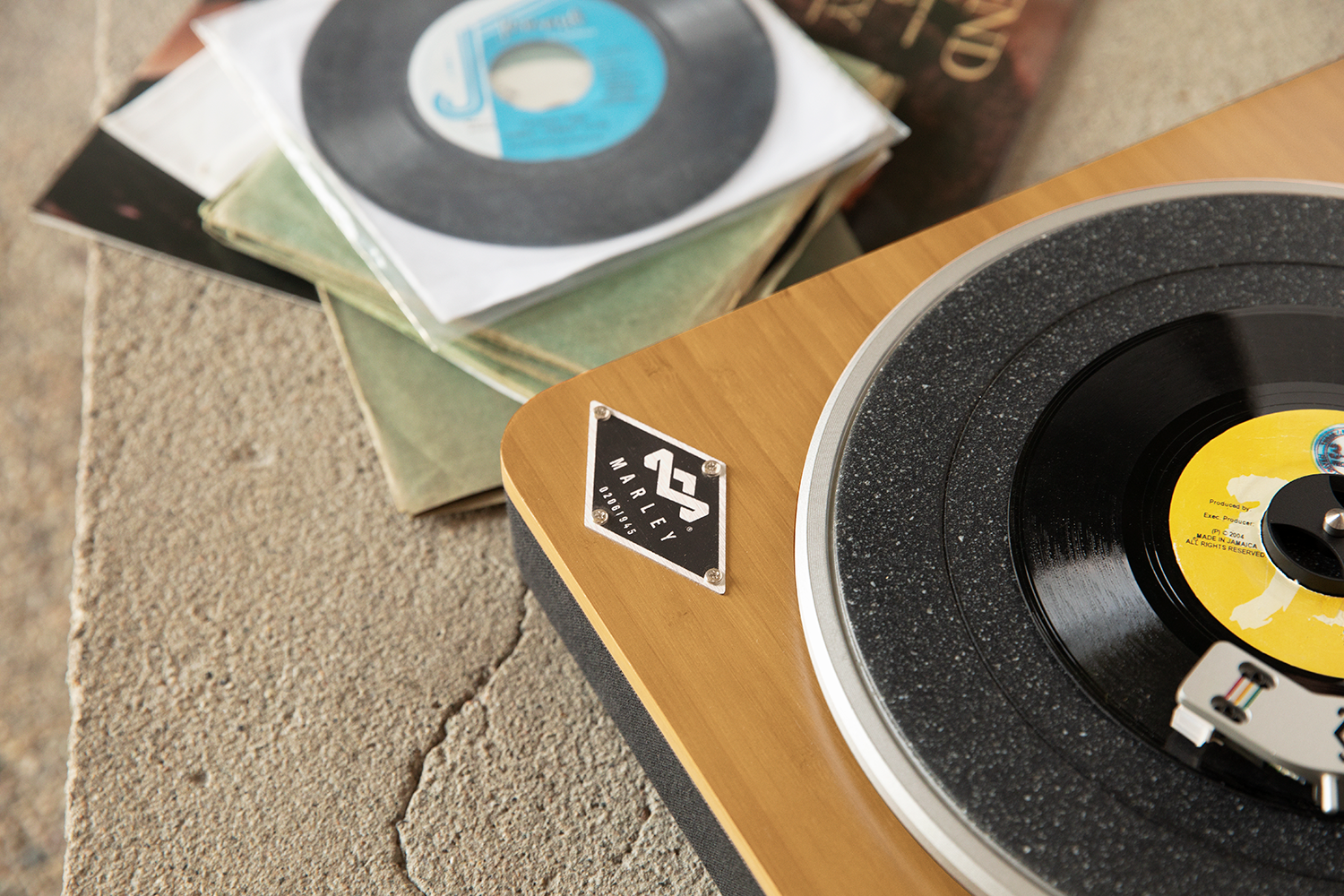 Een platenspeler met een vinylplaat die afspeelt. Vinylplaten staan links.
