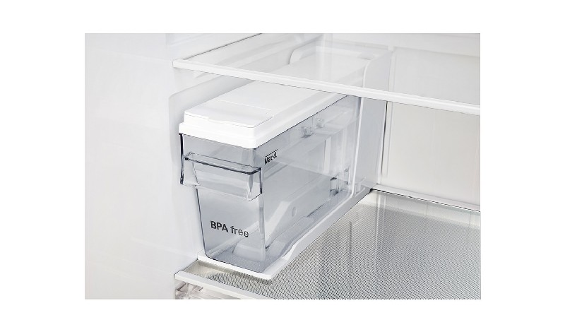 Un recipiente blanco con una parte delantera de plástico transparente, etiquetado como 'sin BPA'. Dentro de una nevera.