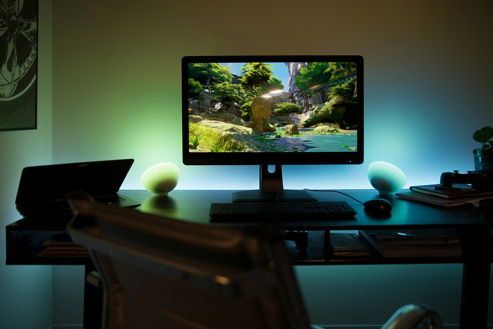Ein Schreibtisch mit einem Computermonitor und zwei bunten Lampen.