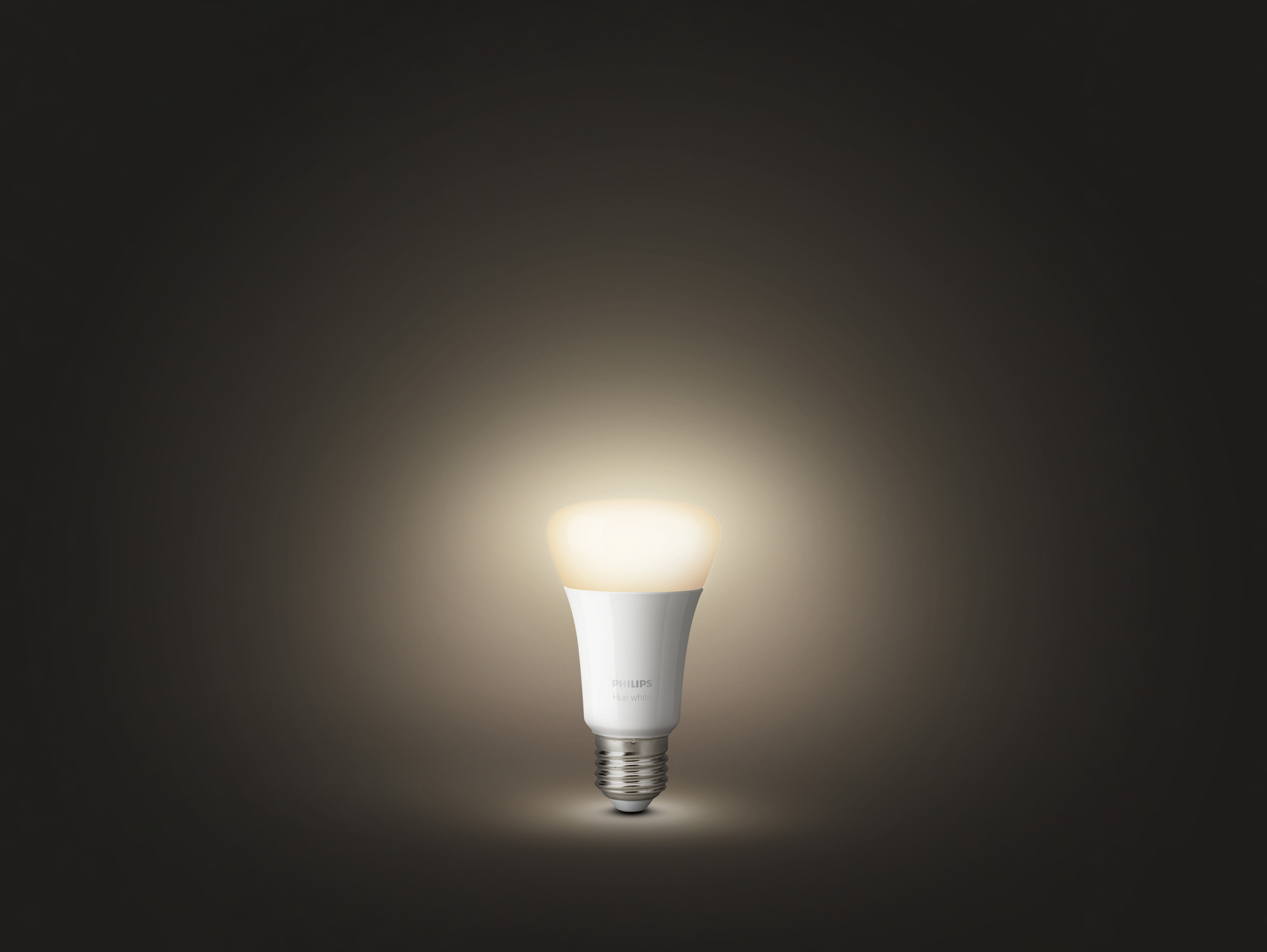 Weiße Philips Hue-Glühbirne leuchtet hell auf dunklem Hintergrund.