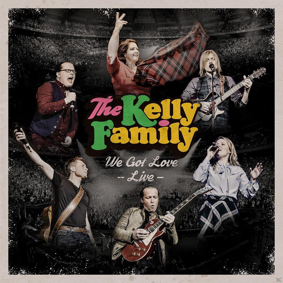 Das Kelly Family-Albumcover mit verschiedenen Bandmitgliedern auf der Bühne. Eine Live-Performance findet statt.