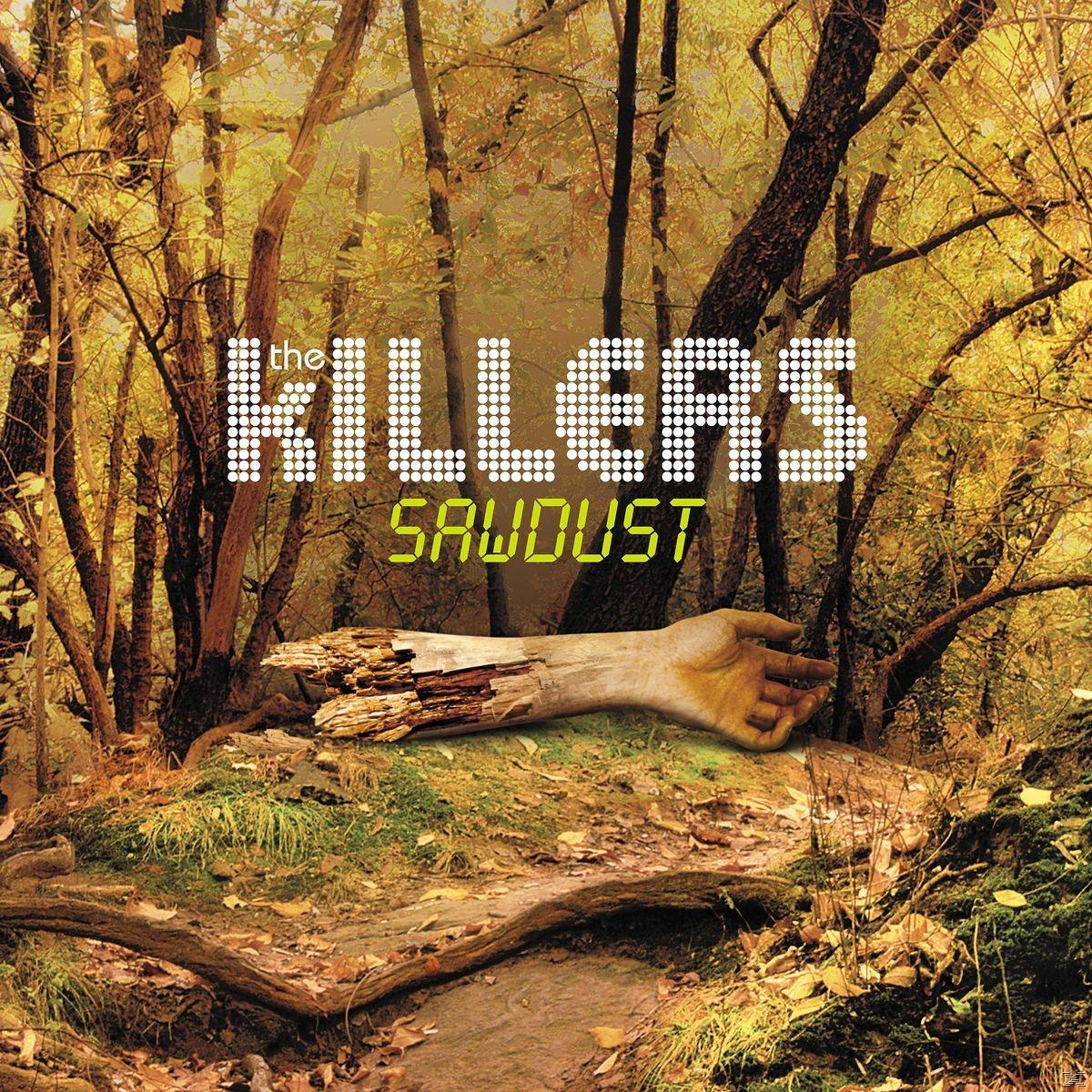 Albumcover, Bandname The Killers und eine Hand, die in einem Wald auf einem Baumstamm ruht.