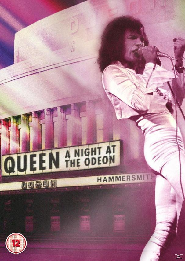 Live concert image of Freddie Mercury singing on stage. The Queen logo is in the background.