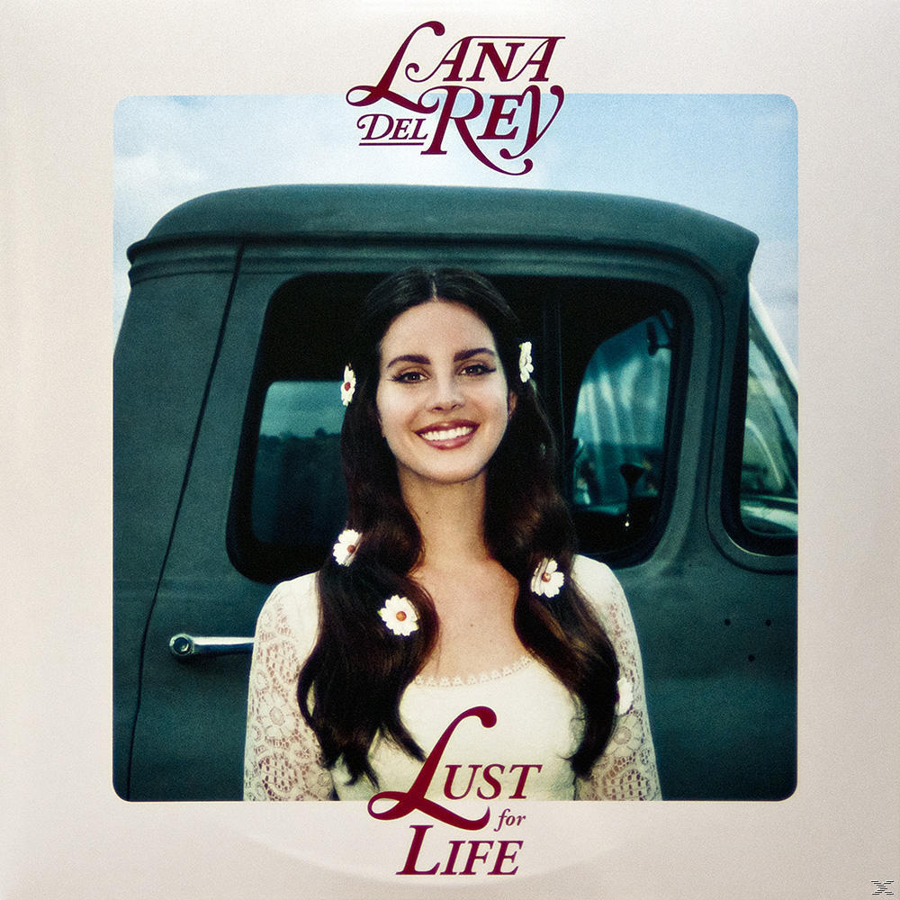 Lana Del Rey album borítója: Mosolygó nő virágokkal a hajában, egy teherautó előtt. 'Lust For Life' cím.