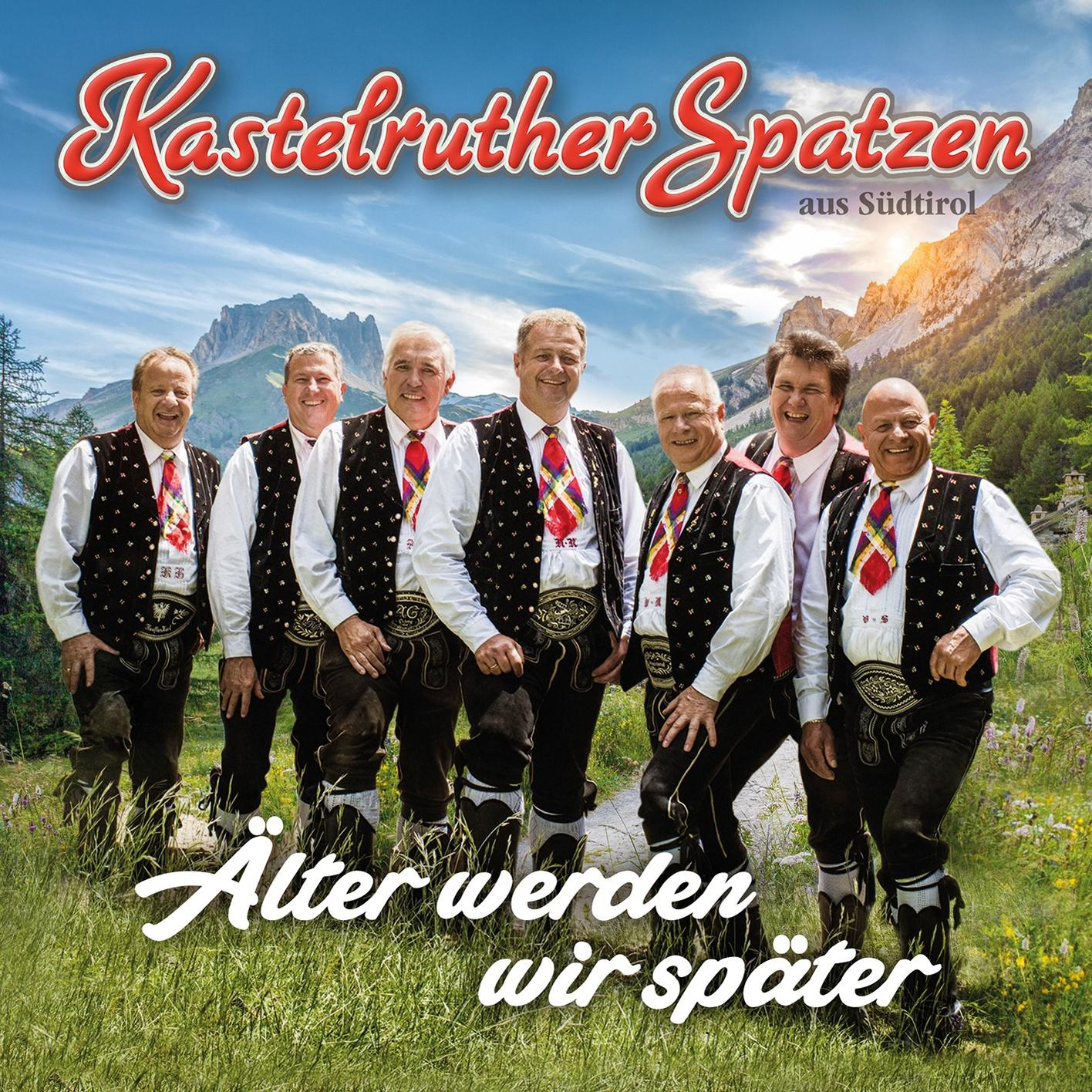 Eine Gruppe von Männern in traditioneller Kleidung, die vor Bergen posieren.