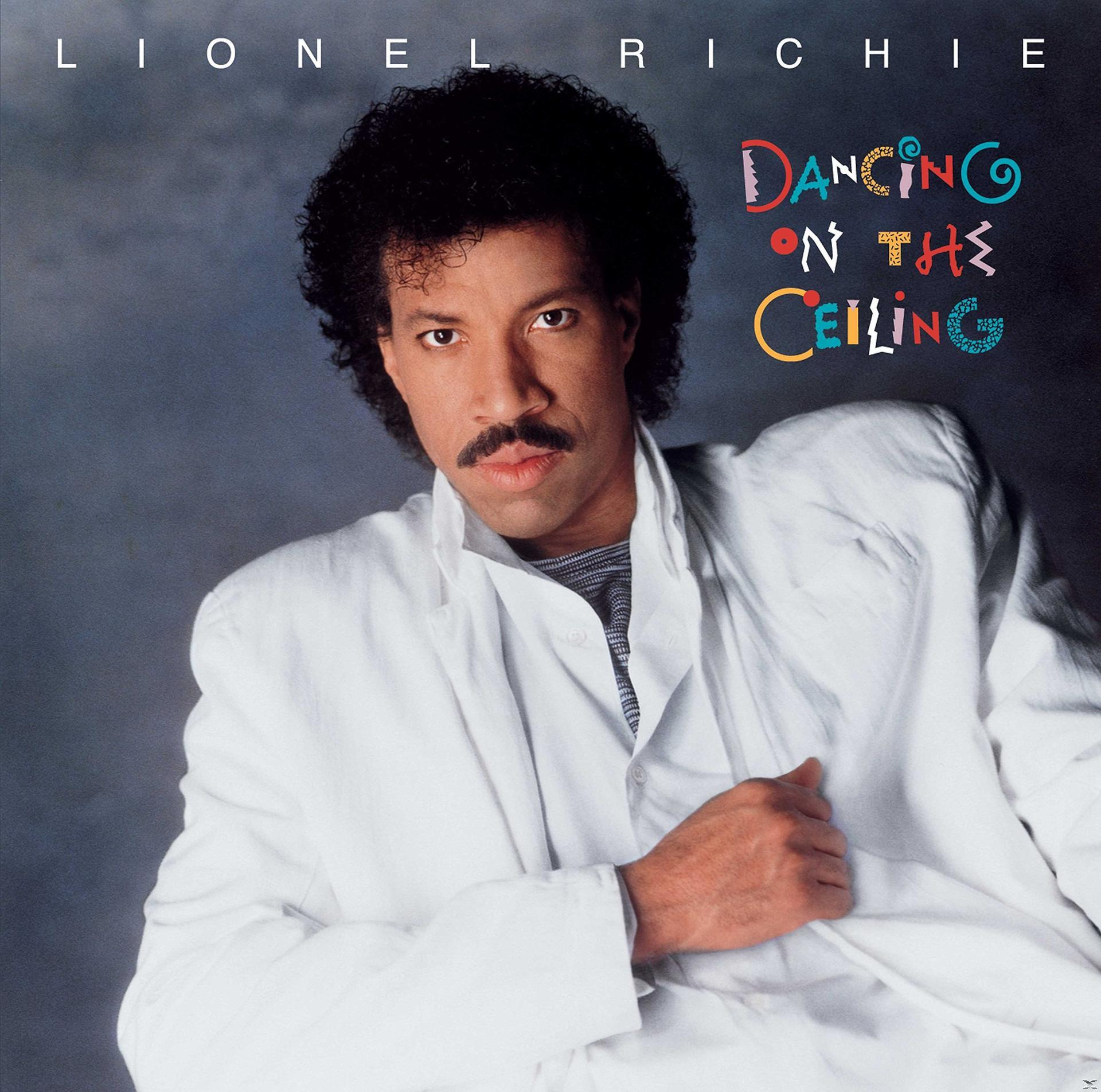Lionel Richie album borítója. Férfi fehér öltönyben. A cím 'Dancing on the Ceiling'. Világos háttér.