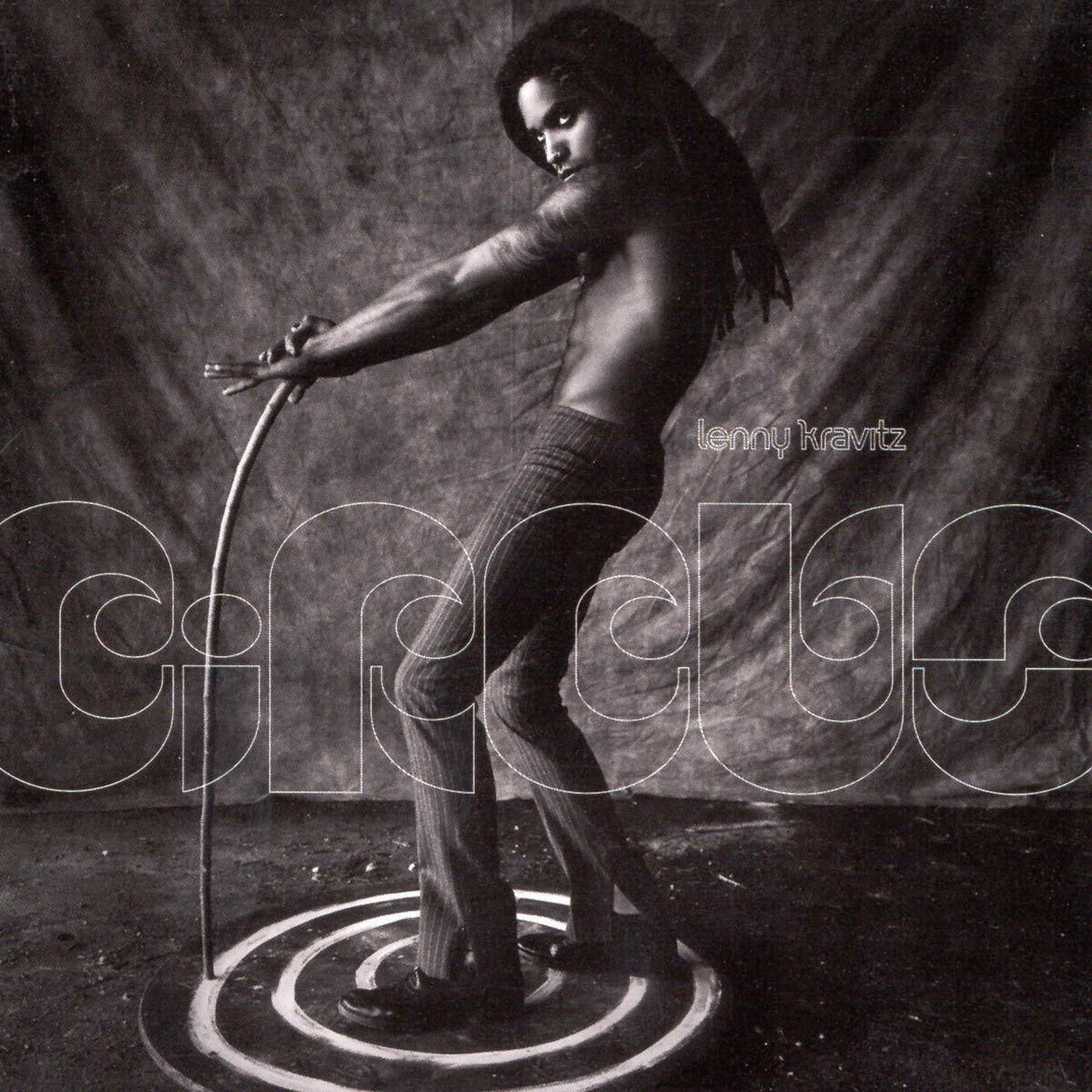 Album borító: Lenny Kravitz egy körben, ívelt rúddal. Fekete-fehér kép.