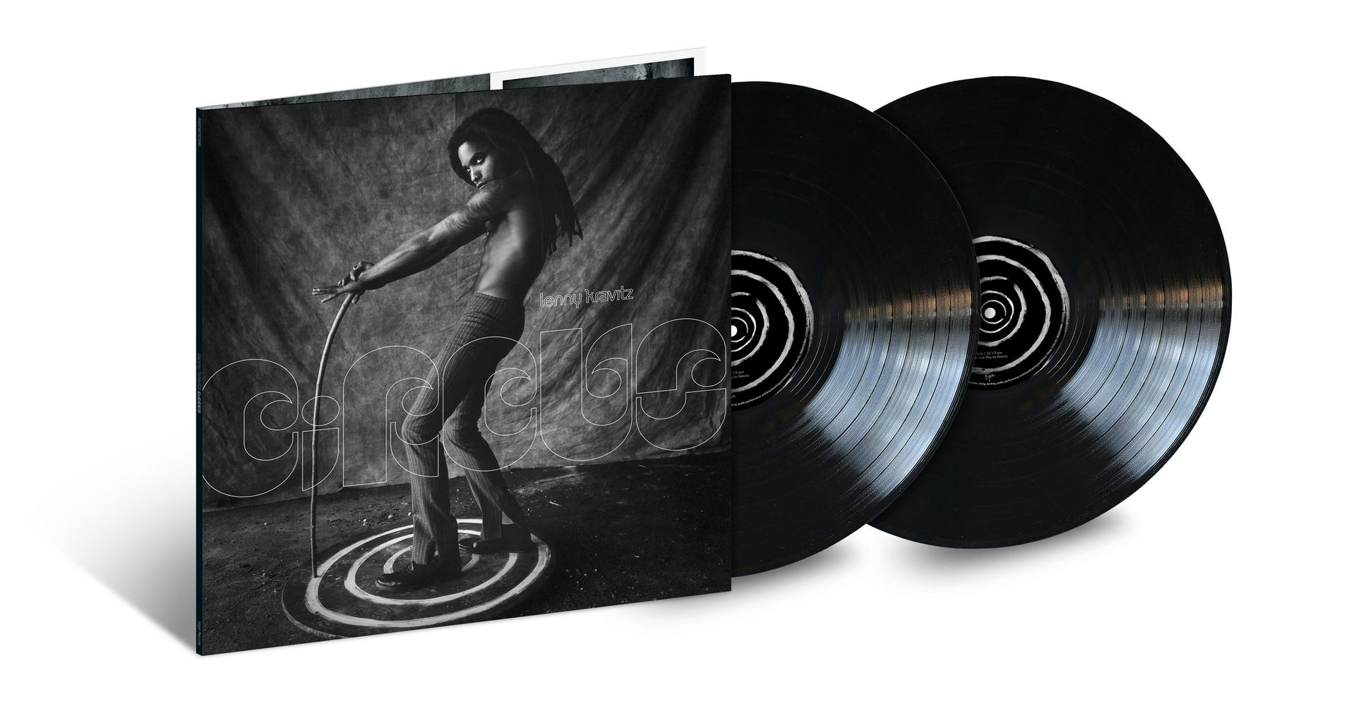 Album borító Lenny Kravitz-cal, sötét színpadon, mellette két fekete bakelit lemez.