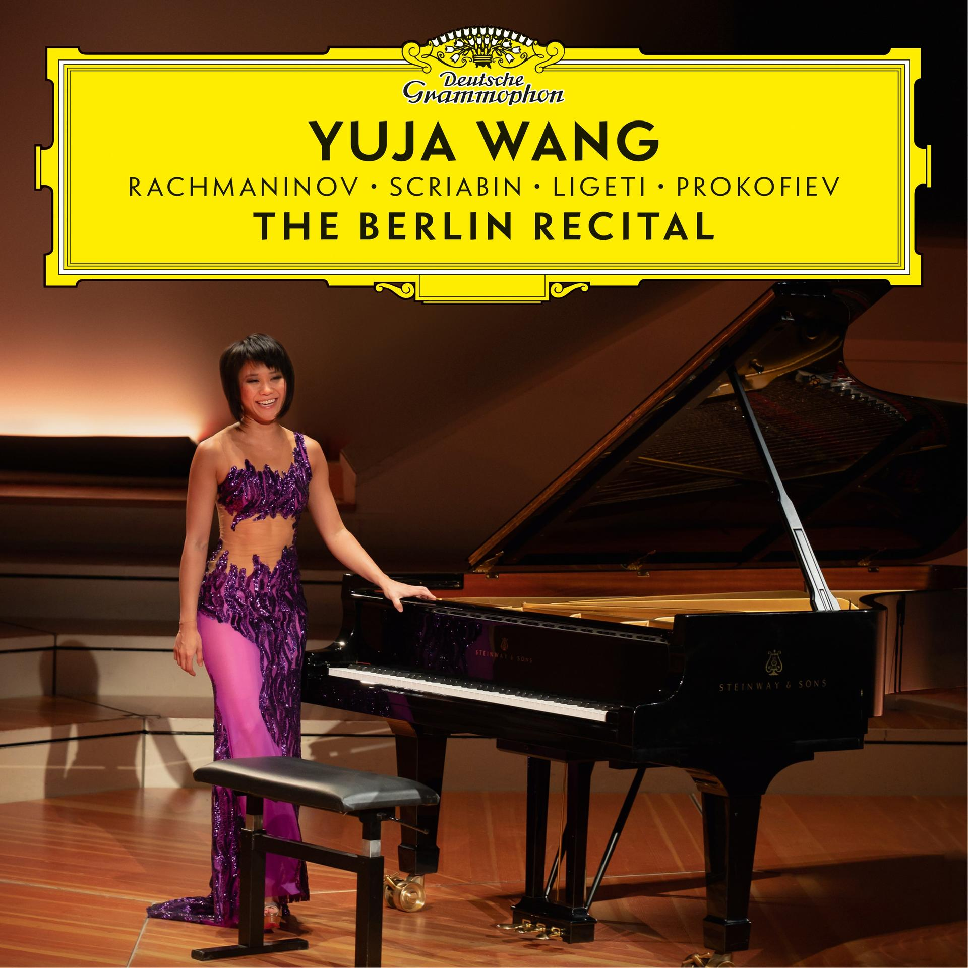 Yuja Wang lila ruhában a zongoránál, színpadi háttér, sárga banner.