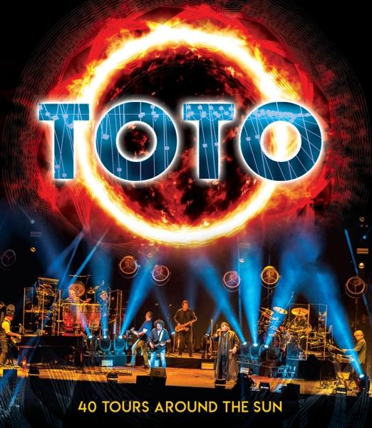 Konzertbühne mit einer Band. TOTO-Logo und Text '40 TOURS AROUND THE SUN' sind sichtbar.