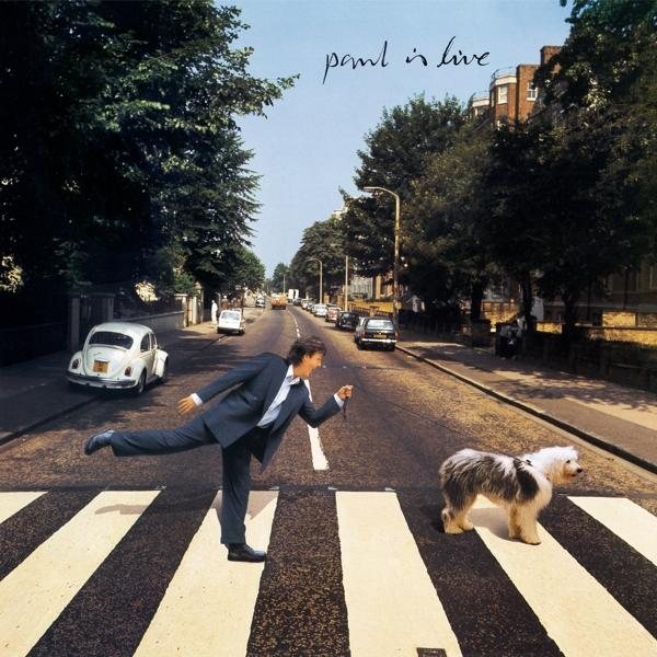 Paul McCartney überquert die Abbey Road, London. Hund rechts. Bäume und Autos auf der Straße.