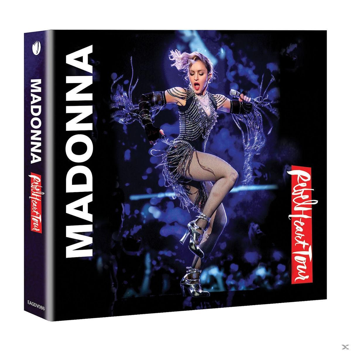 Madonna op een dvd-hoes, optredend op het podium, gekleed in een outfit met studs en hoge hakken. De titel is 'Rebel Heart Tour'.