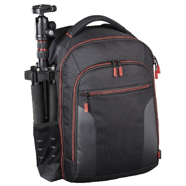 Mochila de cámara negra y roja con un trípode adjunto al costado.