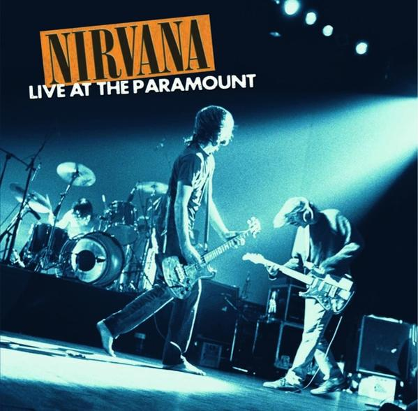 Nirvana Live at the Paramount Albumcover. Zwei Männer spielen Gitarre auf der Bühne, ein Schlagzeuger im Hintergrund.