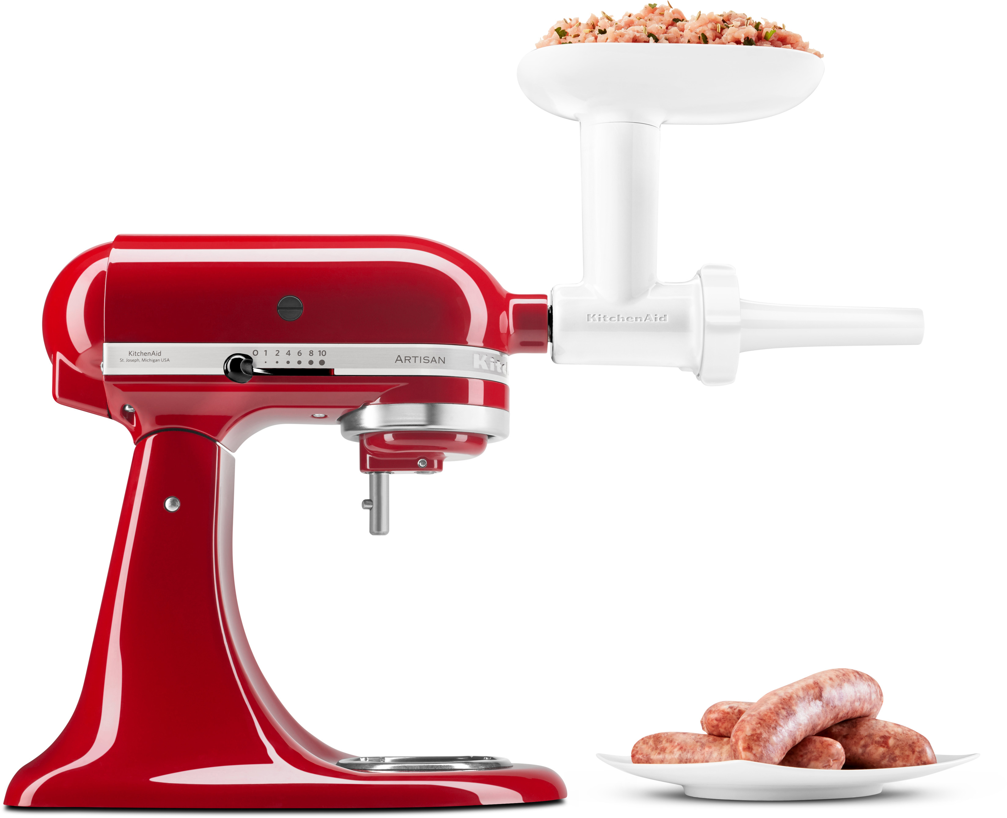 Ein roter KitchenAid-Mixer mit einem Fleischwolf-Aufsatz und einer Platte mit Würstchen daneben.