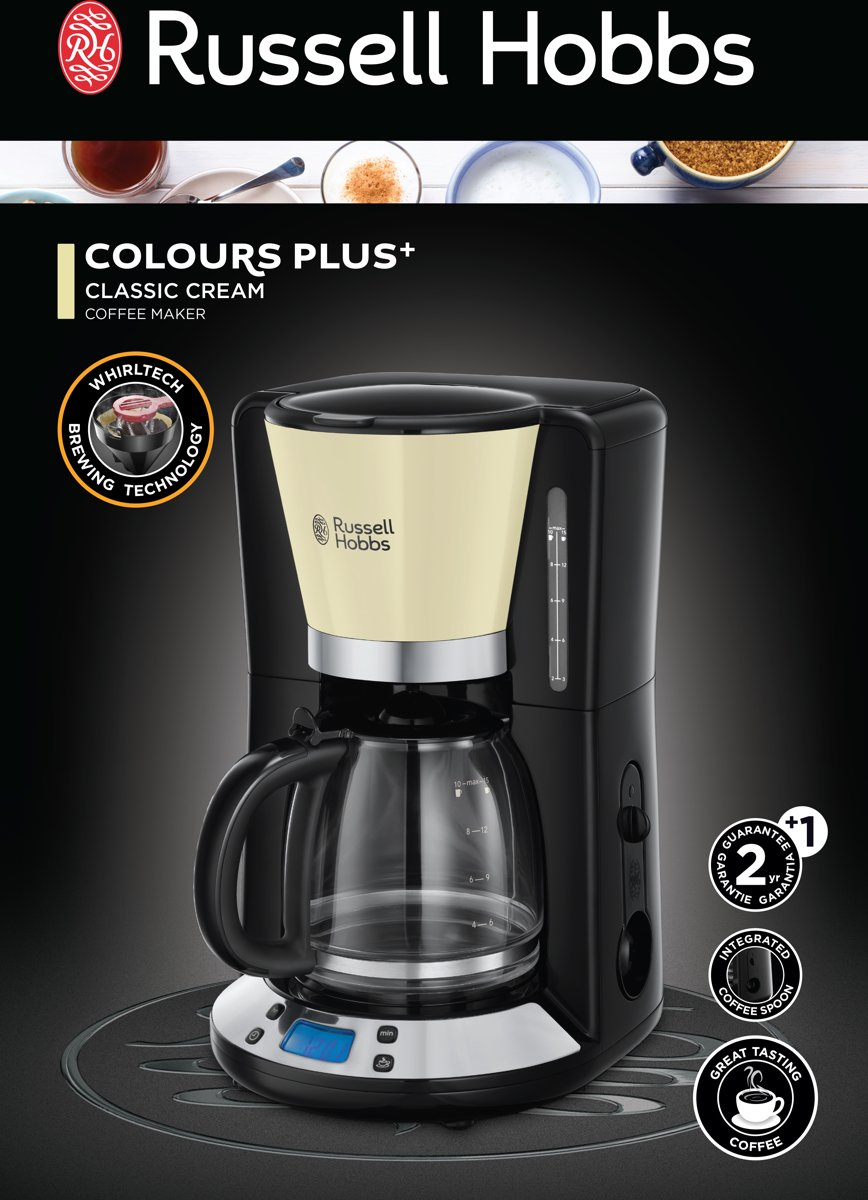 Black and cream coffee maker with glass carafe, on a black surface, with a top view of coffee beans.