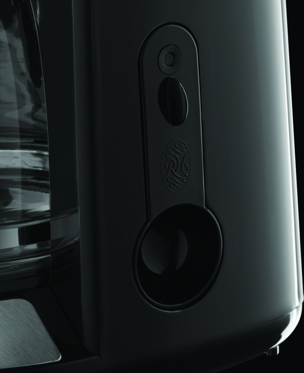 Close-up of a black coffee machine. The details include buttons, holes and a water level indicator.