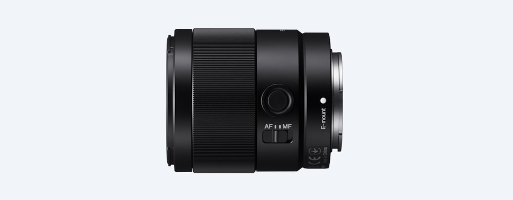 Schwarze Kameralinse. Silberner Ring unten. AF/MF-Schalter sichtbar. E-Mount-Markierung sichtbar.