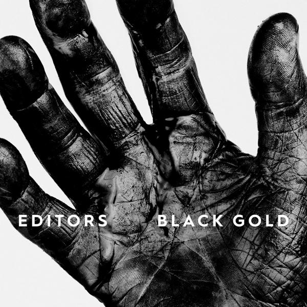 Zwarte hand bedekt met zwarte verf. Tekst: 'EDITORS BLACK GOLD'.