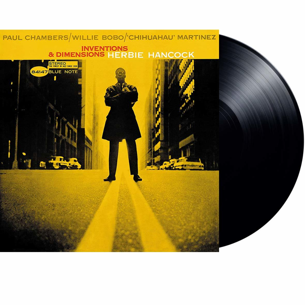 Albumcover: Mann zwischen gelben Straßenlinien, Text 'Inventions & Dimensions'.