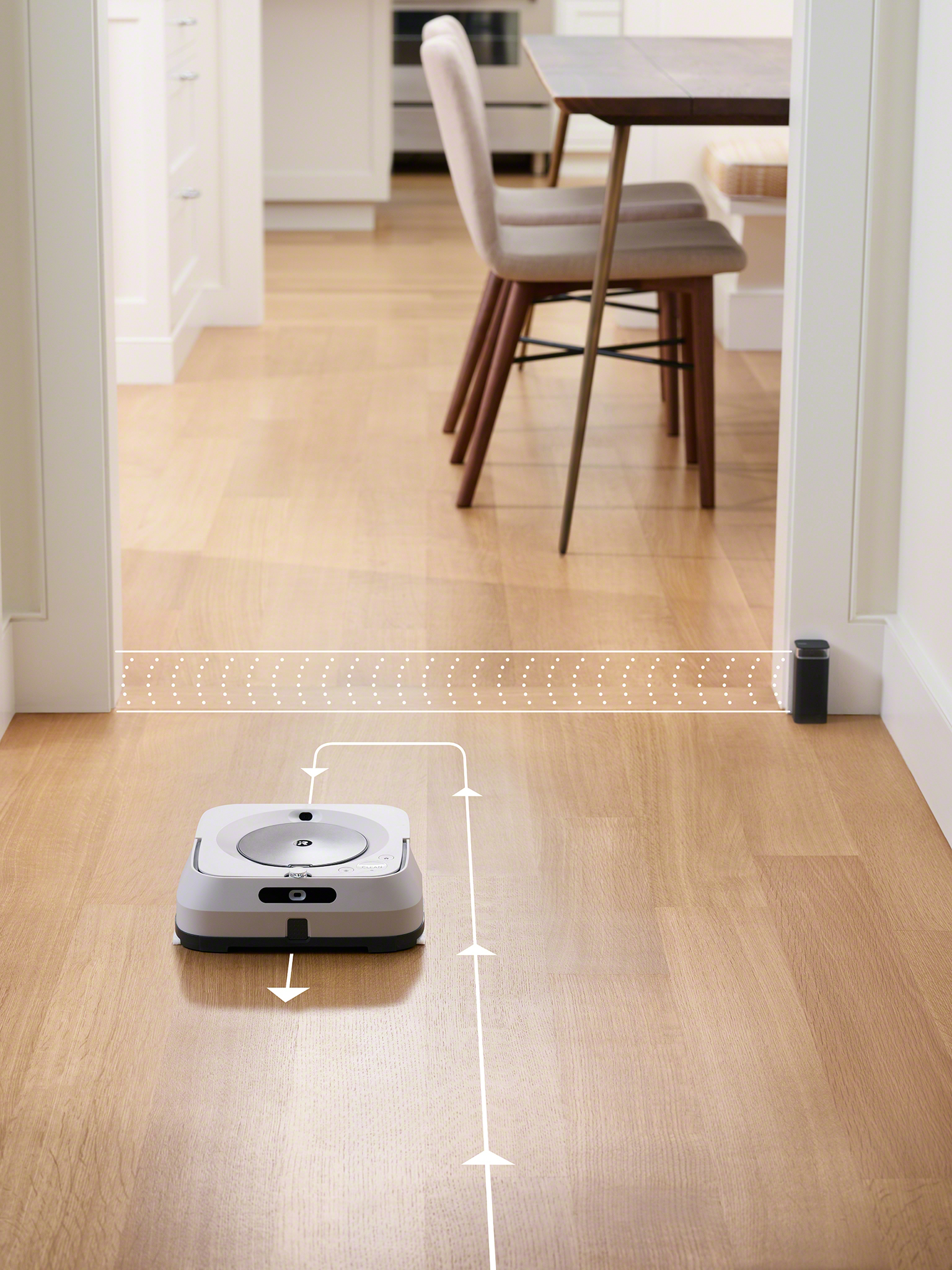 A robot vacuum cleaner on a wooden floor, the path is indicated by a white line.