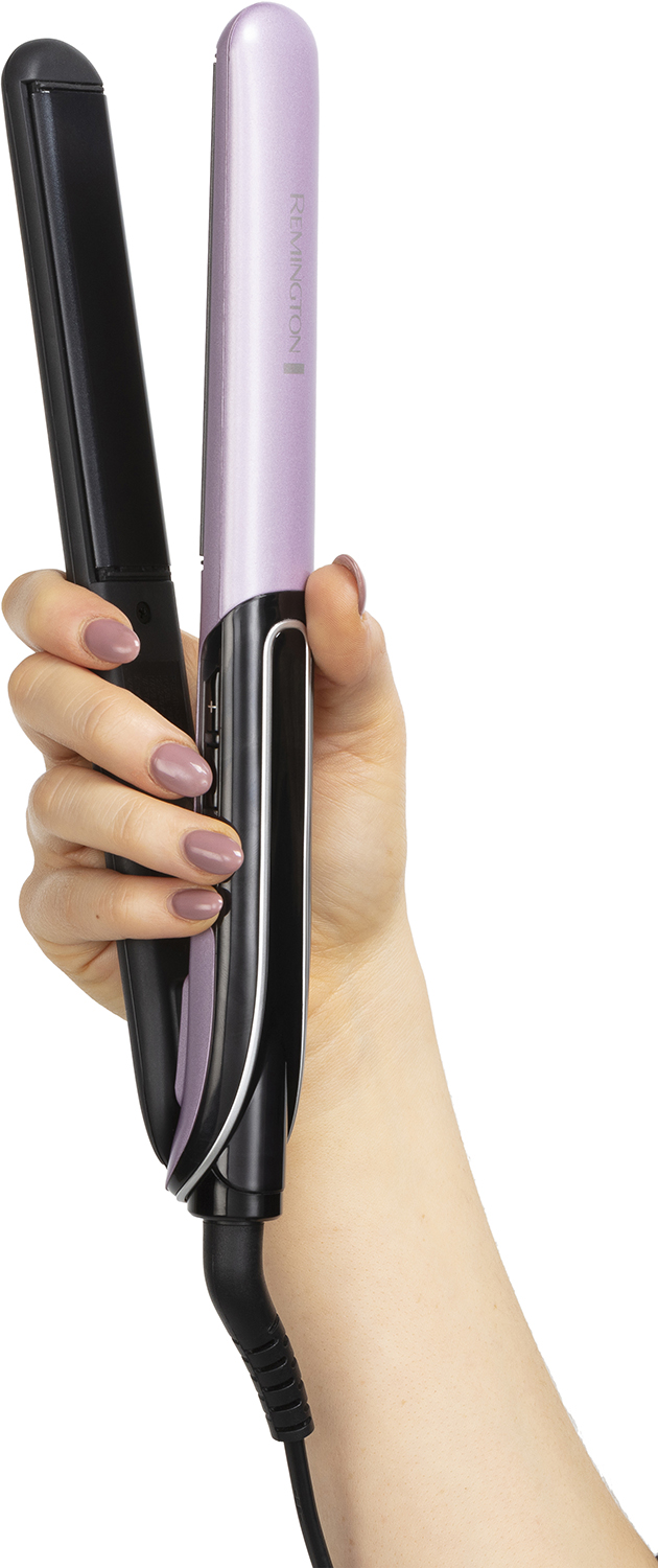 Hand holding a black and pink hair straightener. The cord is black.