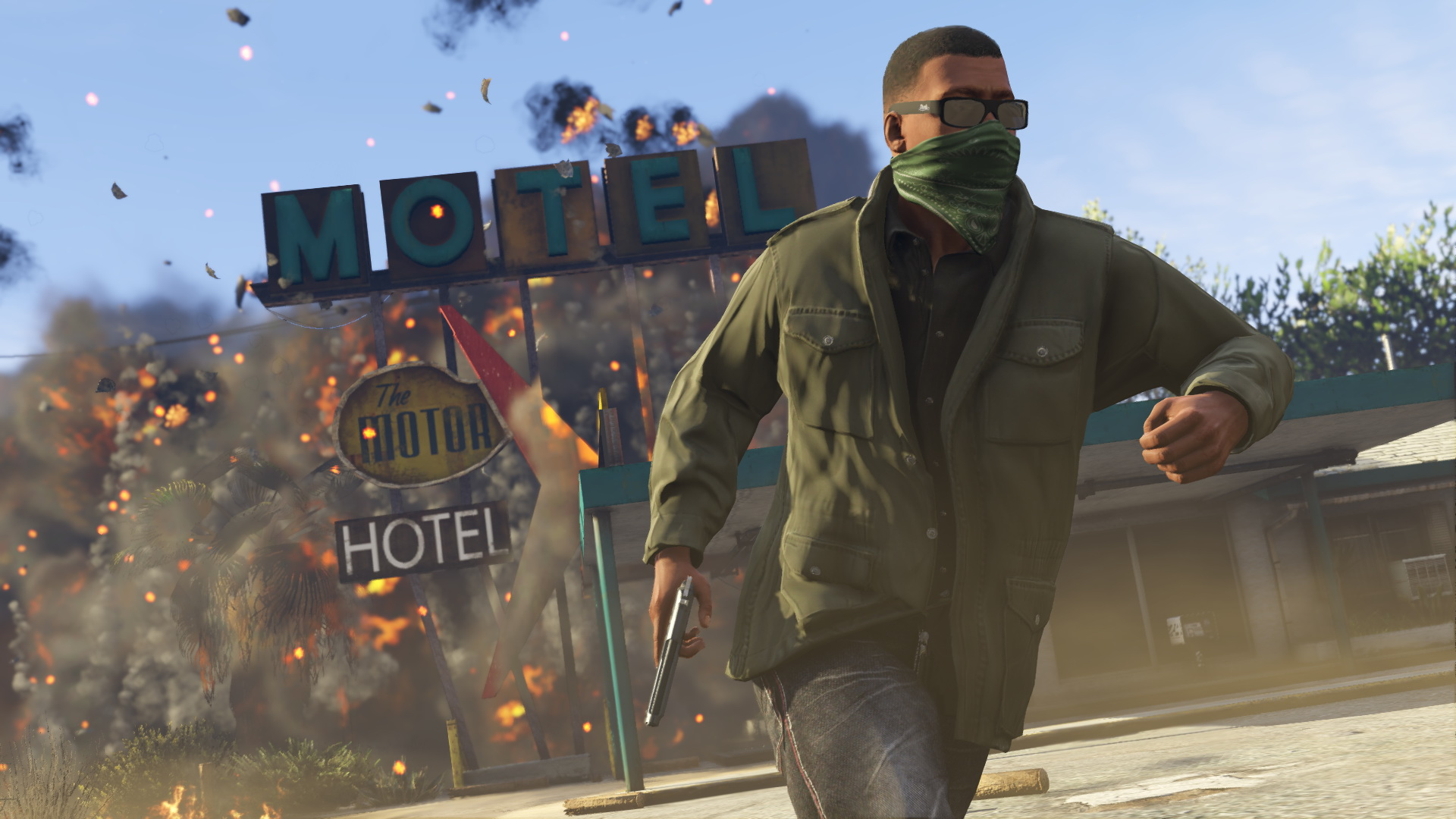 Un homme en veste verte et bandana fuit une explosion ; un enseigne de motel en arrière-plan.