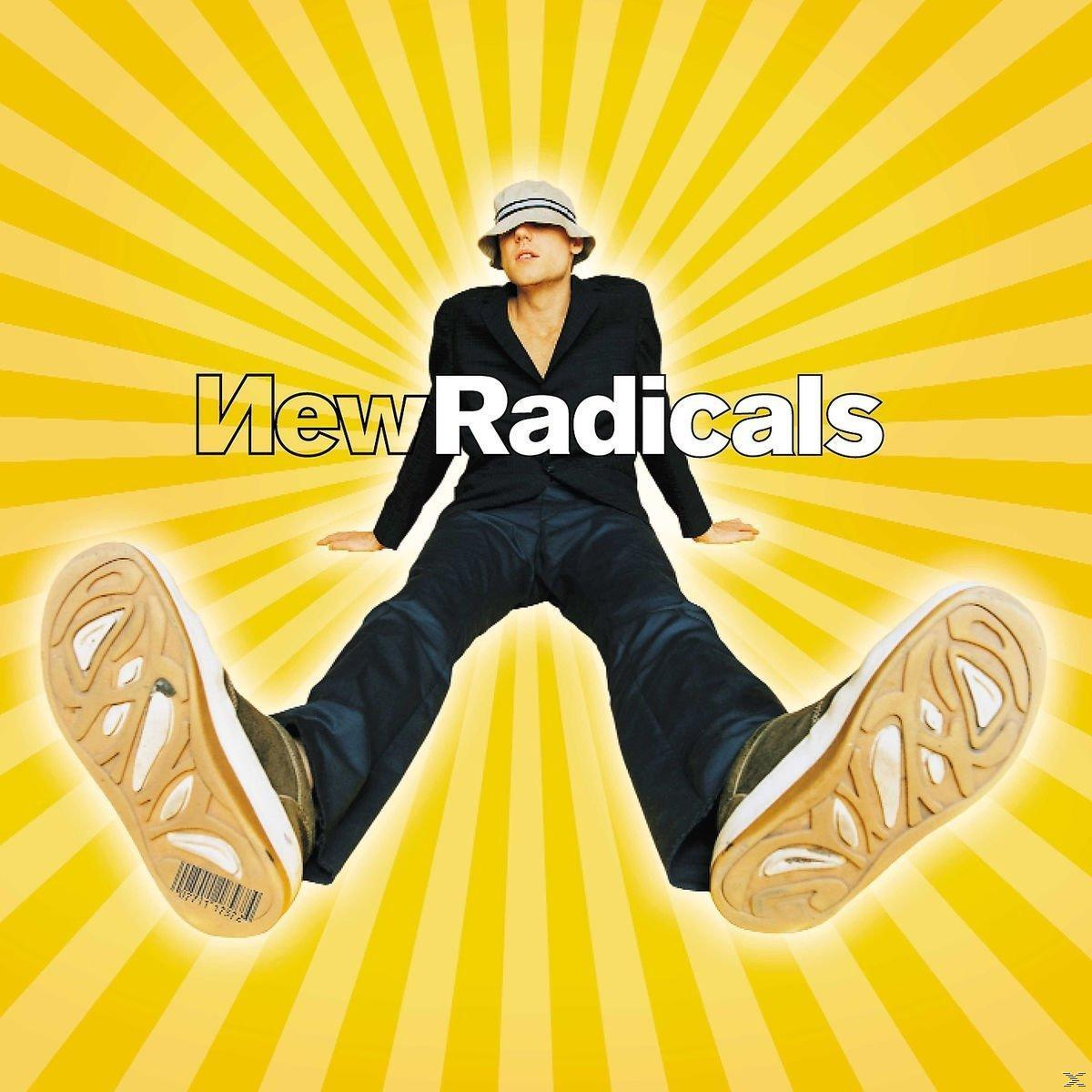 Egy személy öltönyben és kalapban fekszik sárga háttéren, a 'New Radicals' felirattal. Lábai szélesre tártak, a cipőtalpát mutatva.
