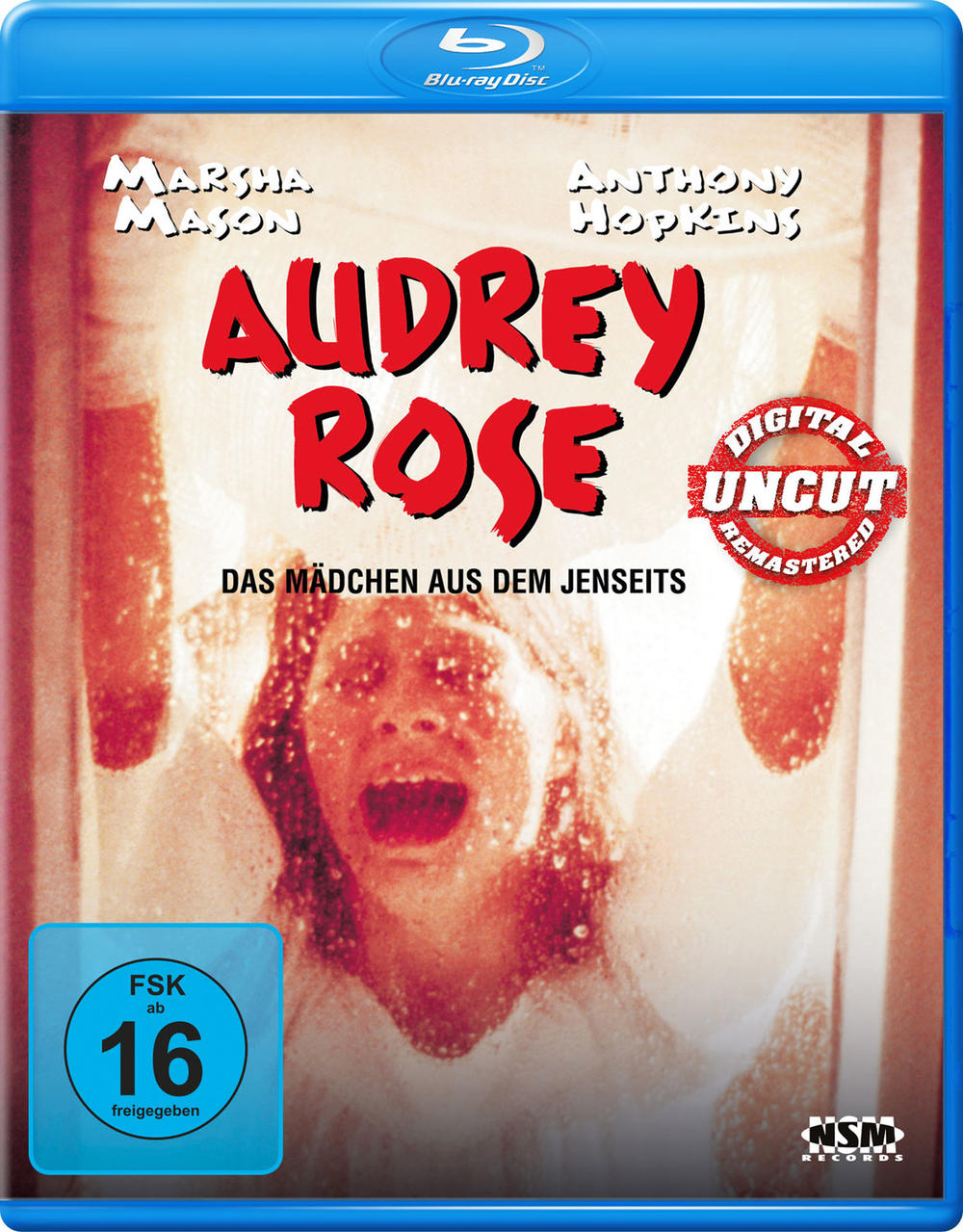 Audrey Rose Filmcover. Gesicht einer Frau in einem Fenster, ängstlich wirkend, roter Text auf blauem Hintergrund.