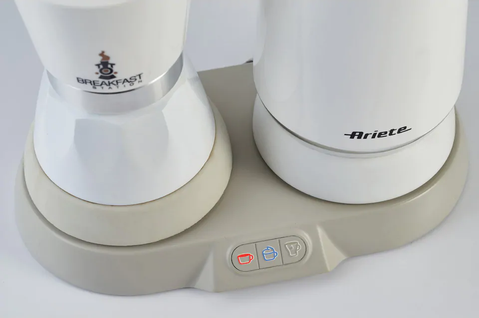 Gros plan d'une cafetière blanche avec le logo argenté Breakfast Station et une bouilloire Ariete séparée.