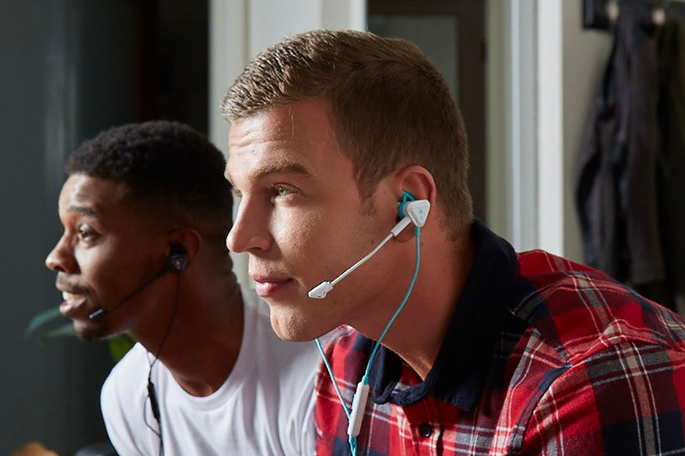 Zwei Männer mit Gaming-Headsets, konzentriert auf einen Bildschirm.