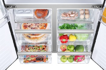 Refrigerador abierto con estantes visibles que contienen alimentos como pizza y frutas.