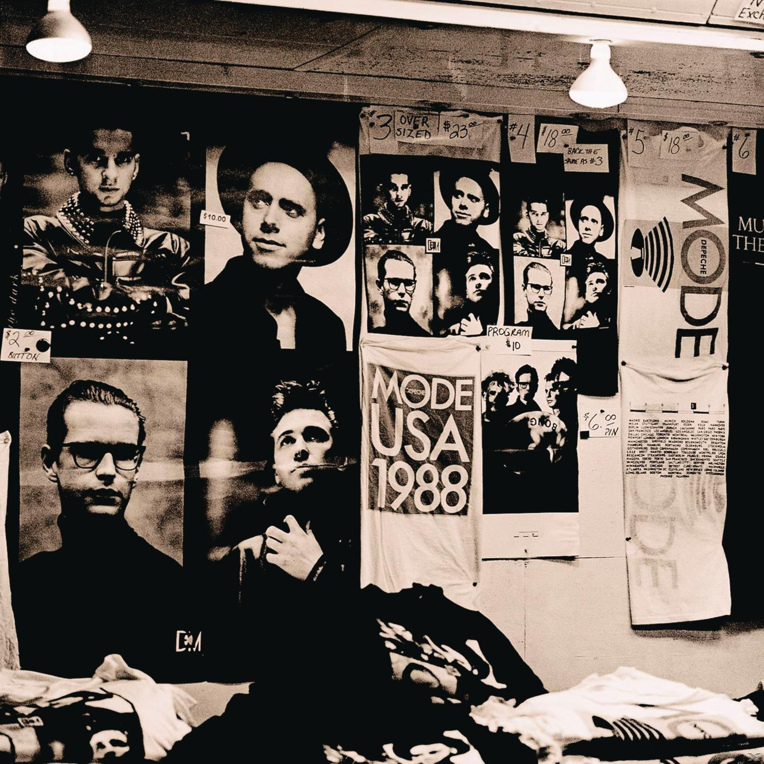 Fekete-fehér fotó egy Depeche Mode árubemutatóról. Tartalmaz posztereket és pólókat.