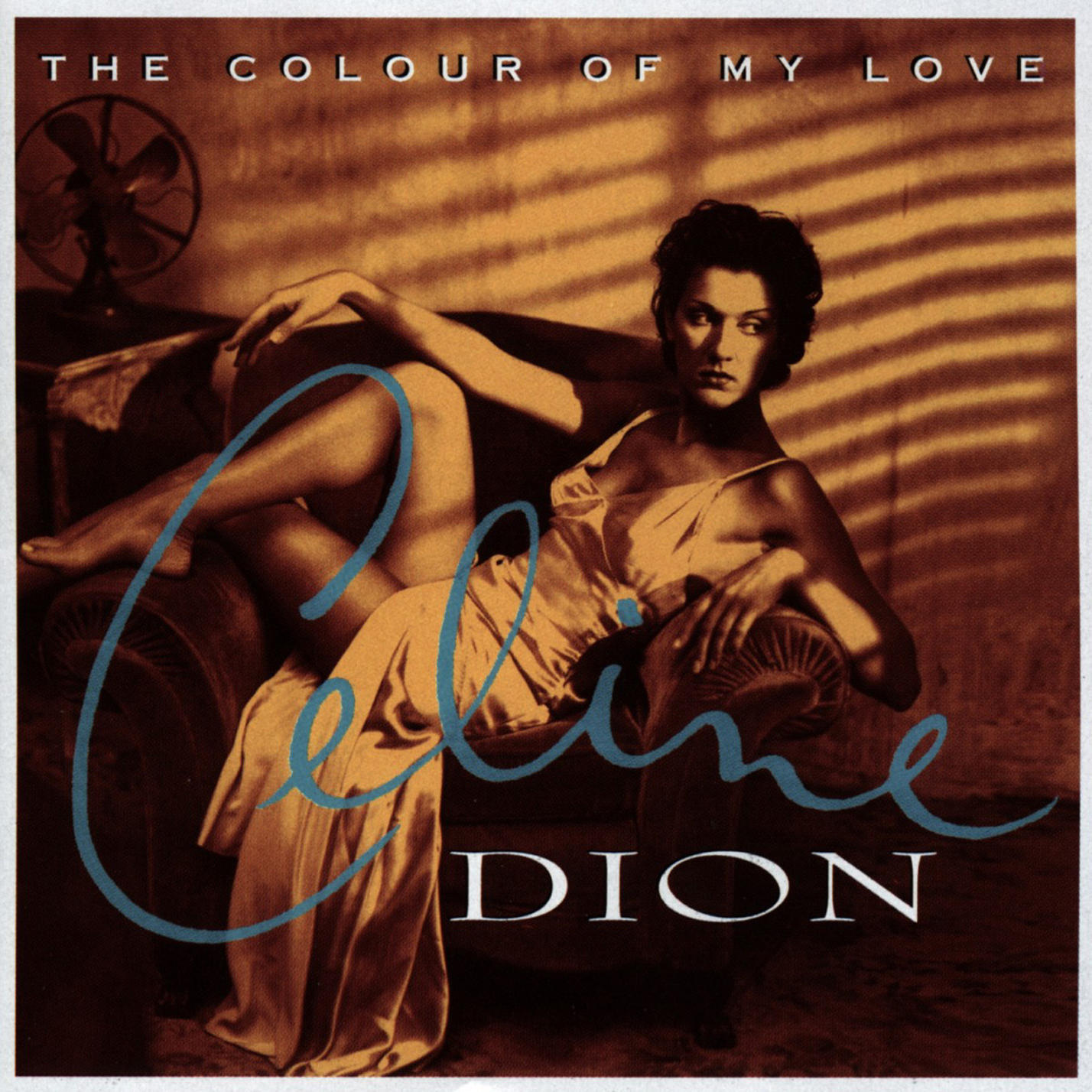 Celine Dion Albumcover. Frau in einem Kleid auf einem Sofa. Blauer Text über einem dunklen Hintergrund.