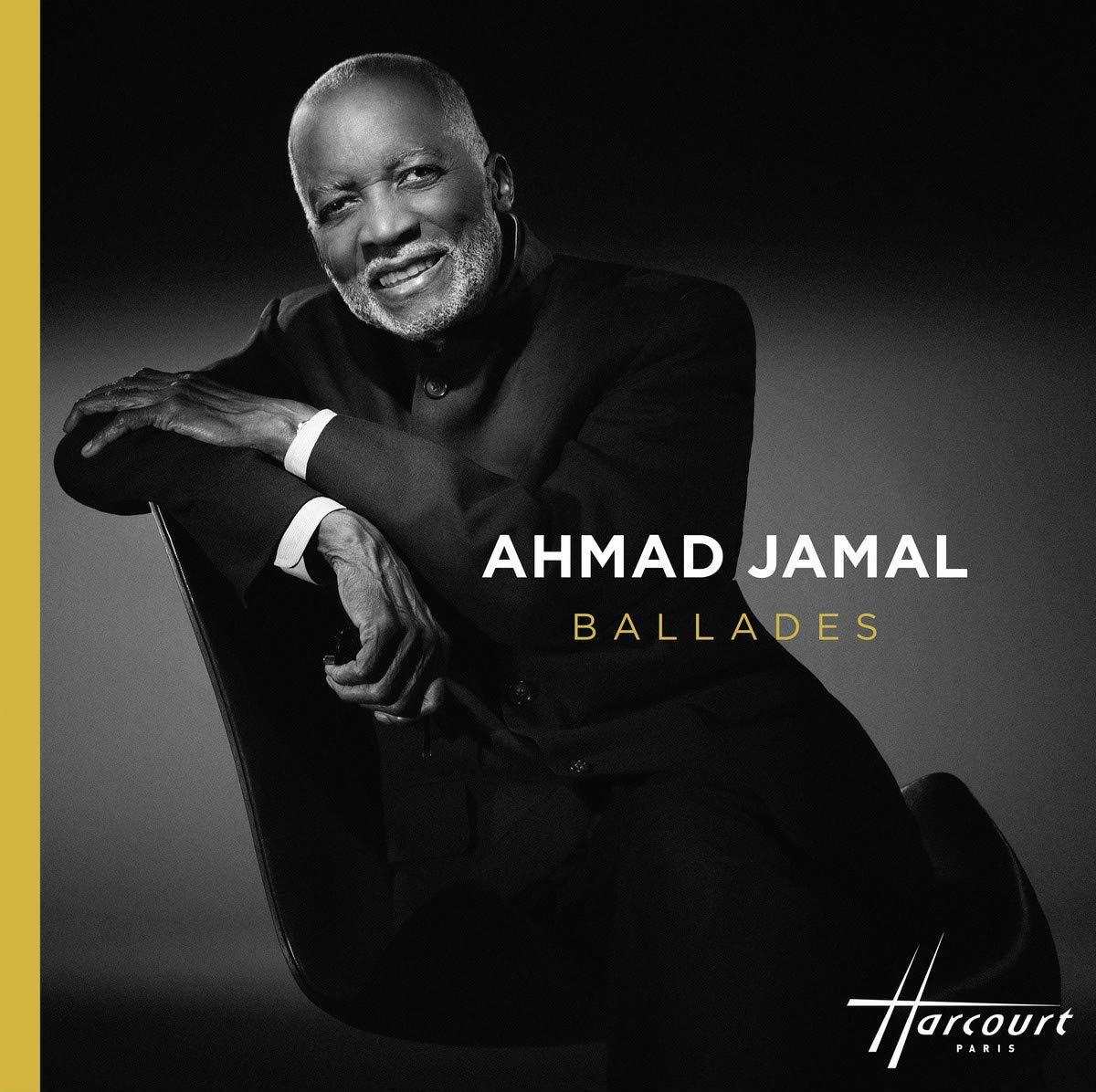 Ahmad Jamal in Anzug sitzt in einem Stuhl. Der Hintergrund ist schwarz und gold.