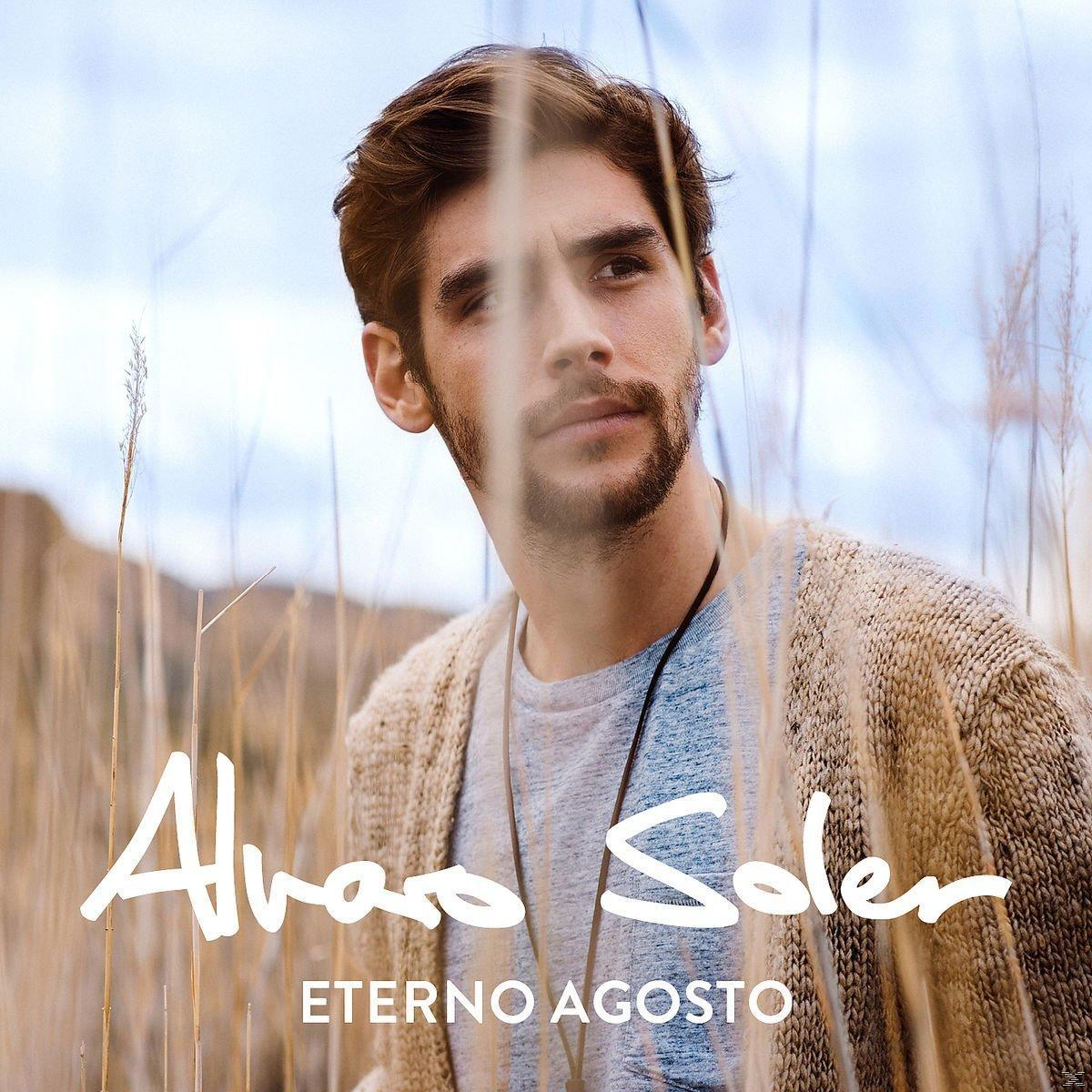 Álvaro Soler steht in hohem Gras, trägt einen Pullover und schaut in die Kamera.