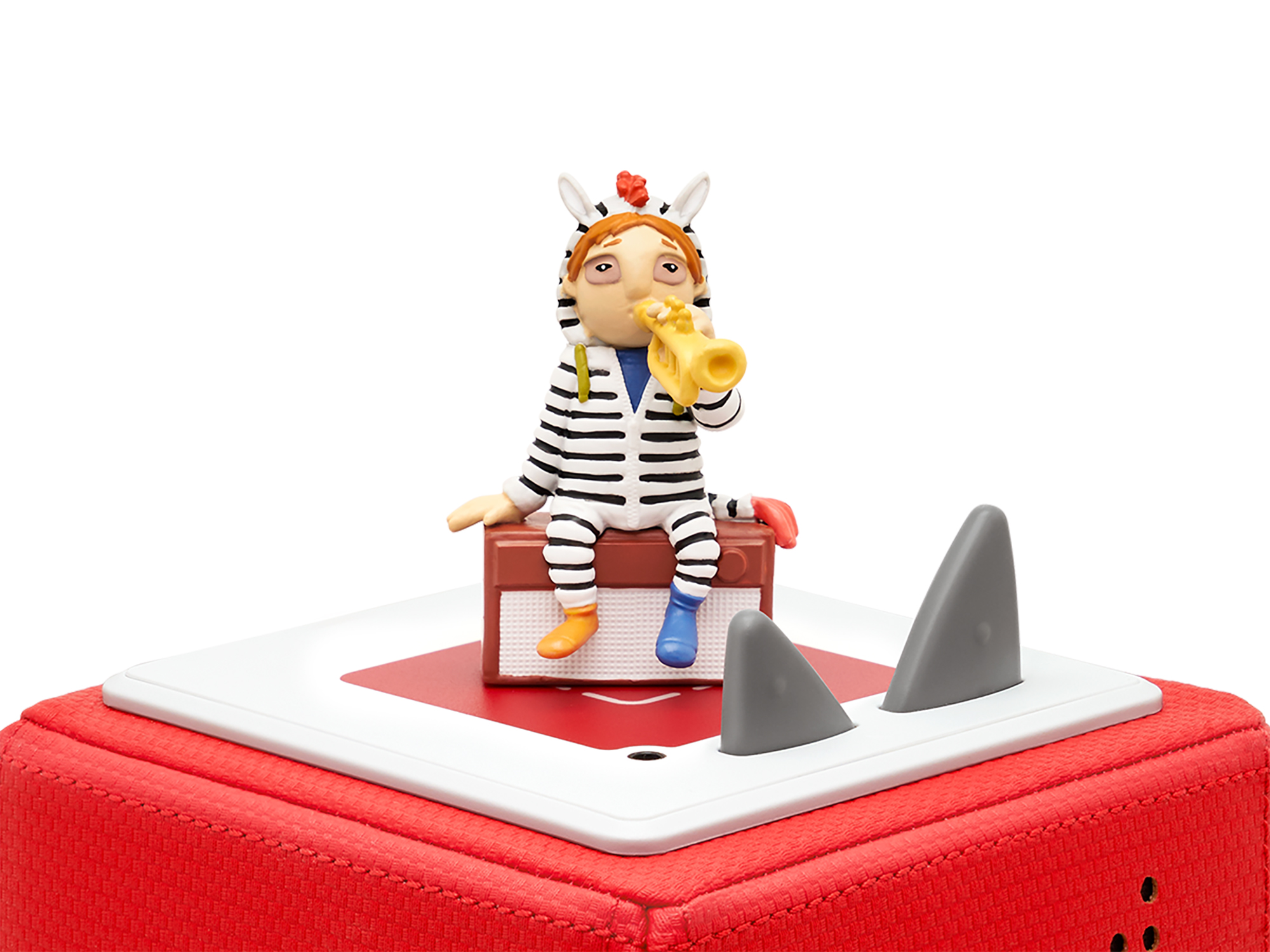 Eine Spielfigur einer als Zebra verkleideten Person auf einer roten Box mit Haifischflossen.