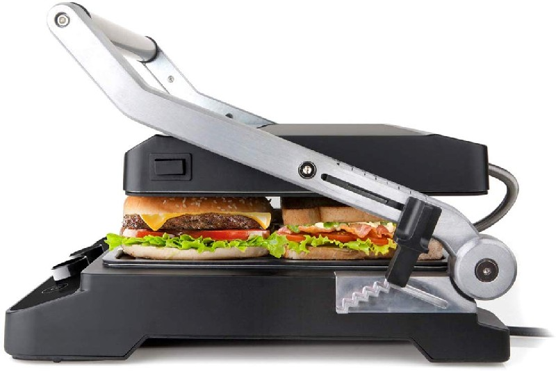 Una sandwichera negra con dos sándwiches, una hamburguesa, sobre fondo blanco.
