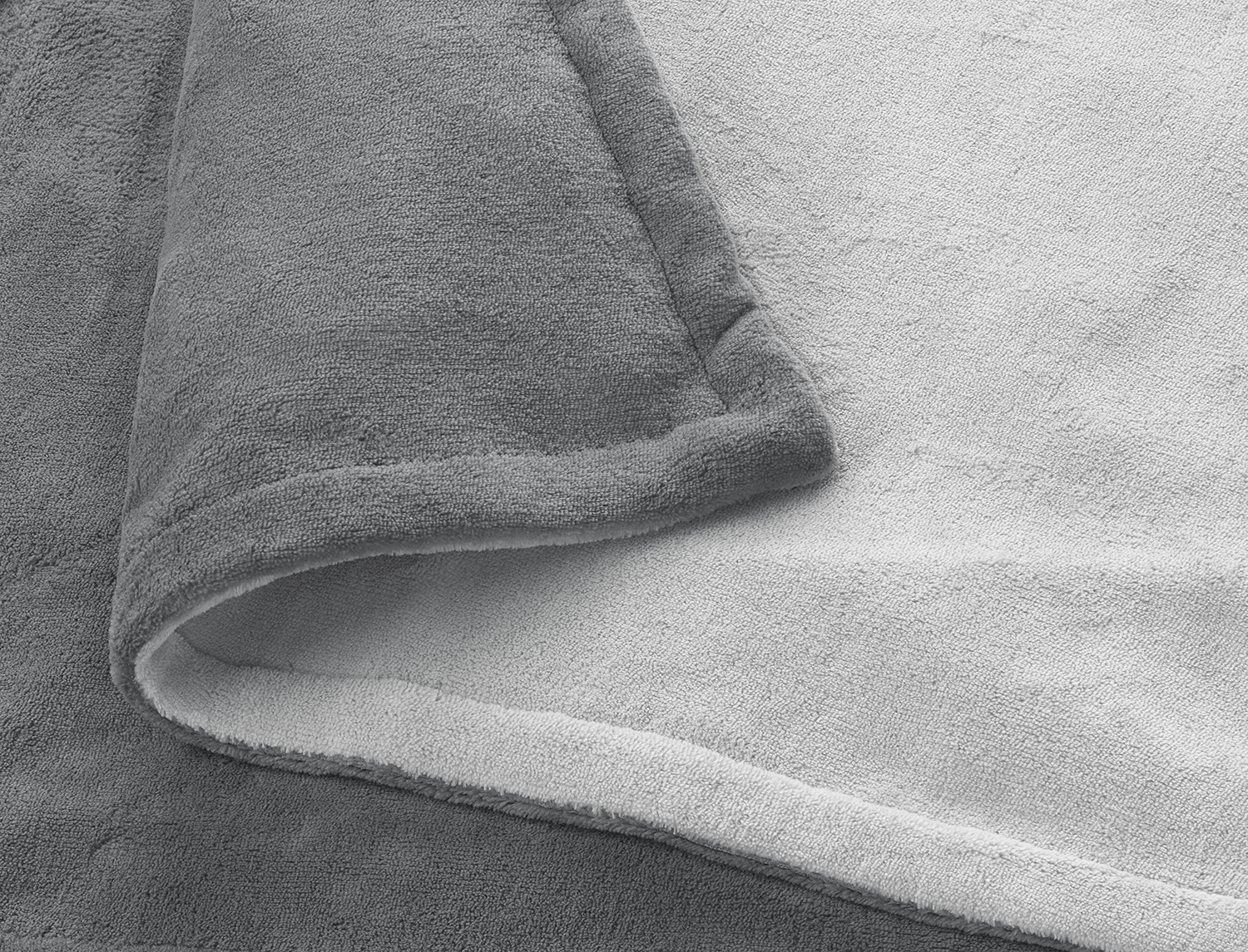 Close-up of a gray and white blanket, folded over.