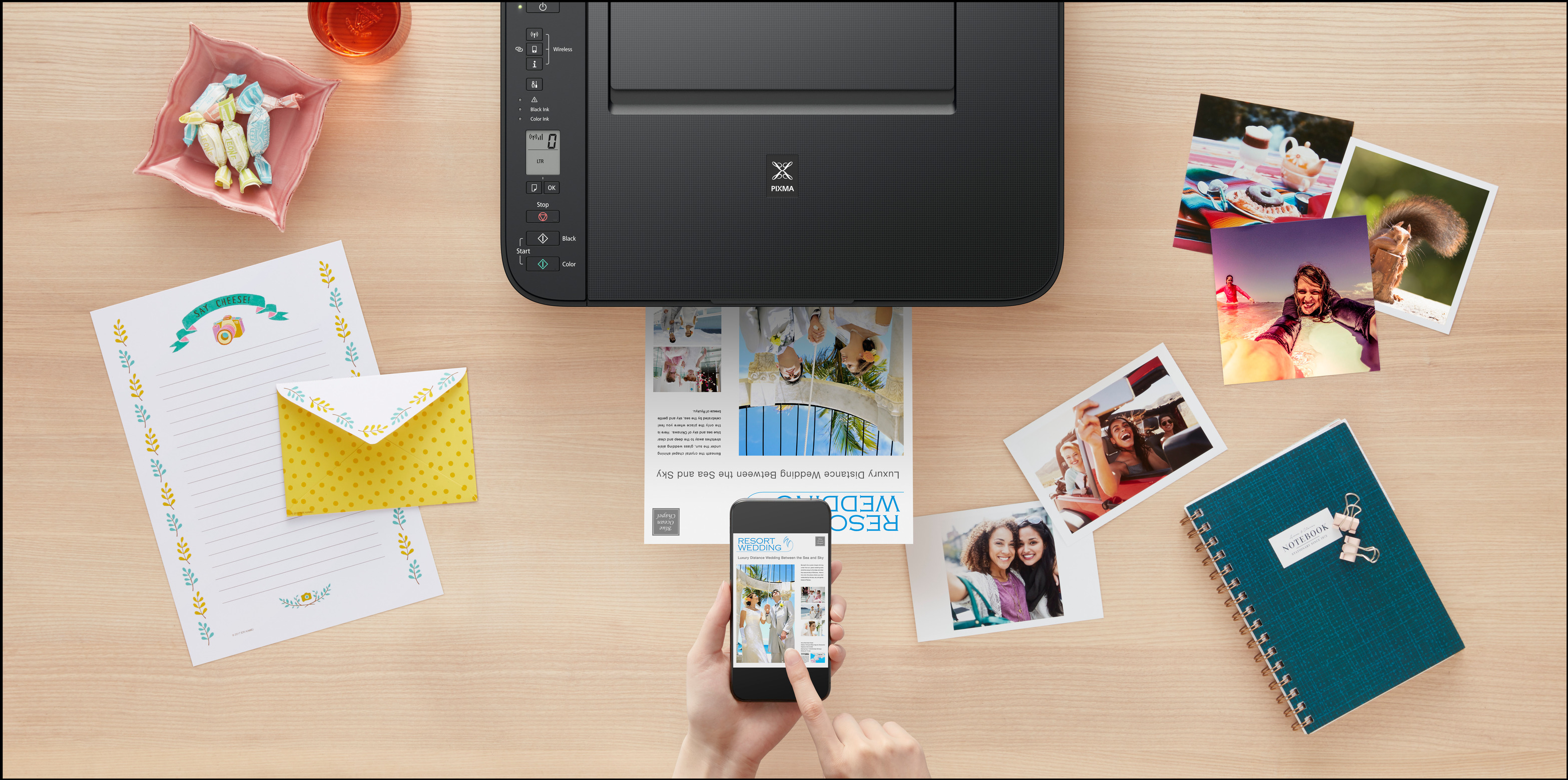 Ein Schreibtisch mit Fotos, gedruckten Dokumenten, einem Telefon und einem Drucker. Die Szene ist gut beleuchtet.