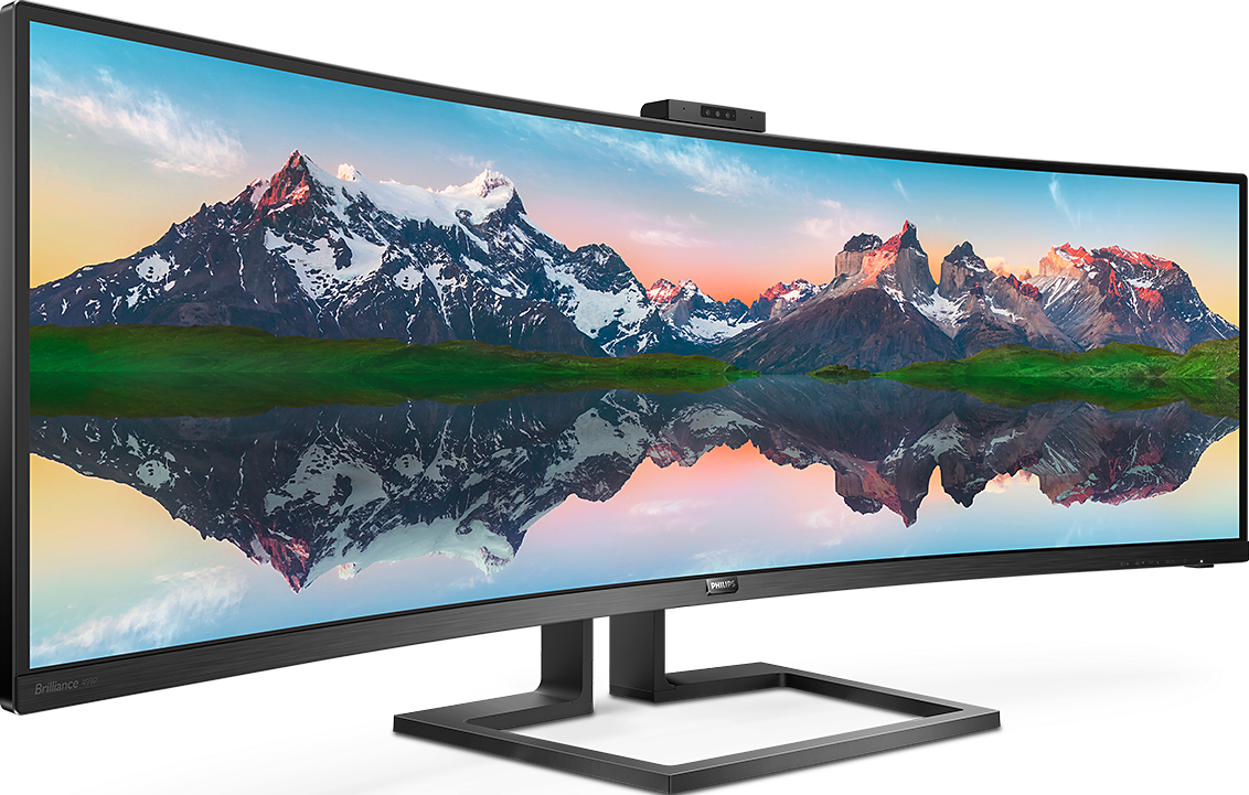 Un ampio monitor Philips curvo mostra un paesaggio montano innevato riflesso nell'acqua su sfondo nero.