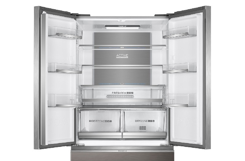Refrigerador abierto de acero inoxidable con múltiples estantes y cajones, vacío por dentro.