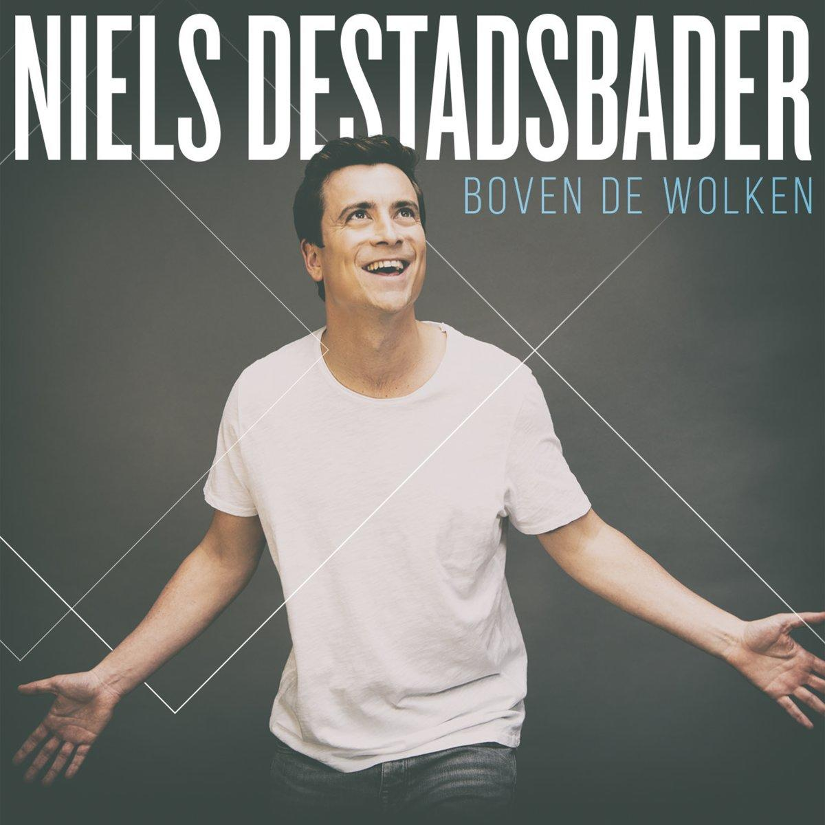 Albumhoes van Niels Destadsbader. Man met open armen, omhoog kijkend, witte tekst.