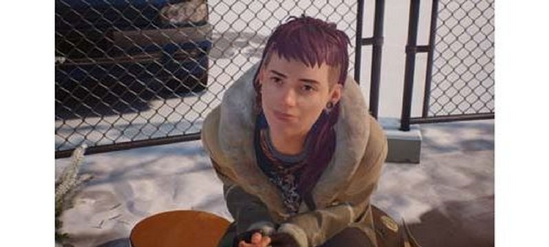 Una persona con cabello corto y morado está sentada frente a una valla, mirando hacia arriba.